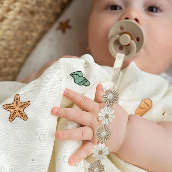 attache tetine motif fleurs bebe avec tetine a la bouche